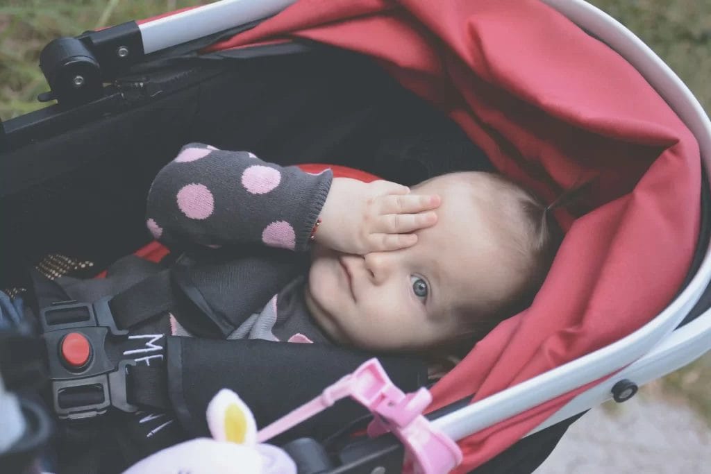 bayi tidur di stroller merah