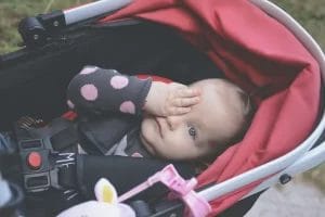 bayi tidur di stroller merah