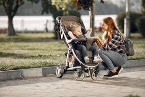 ibu berbicara dengan bayi yang duduk di stroller