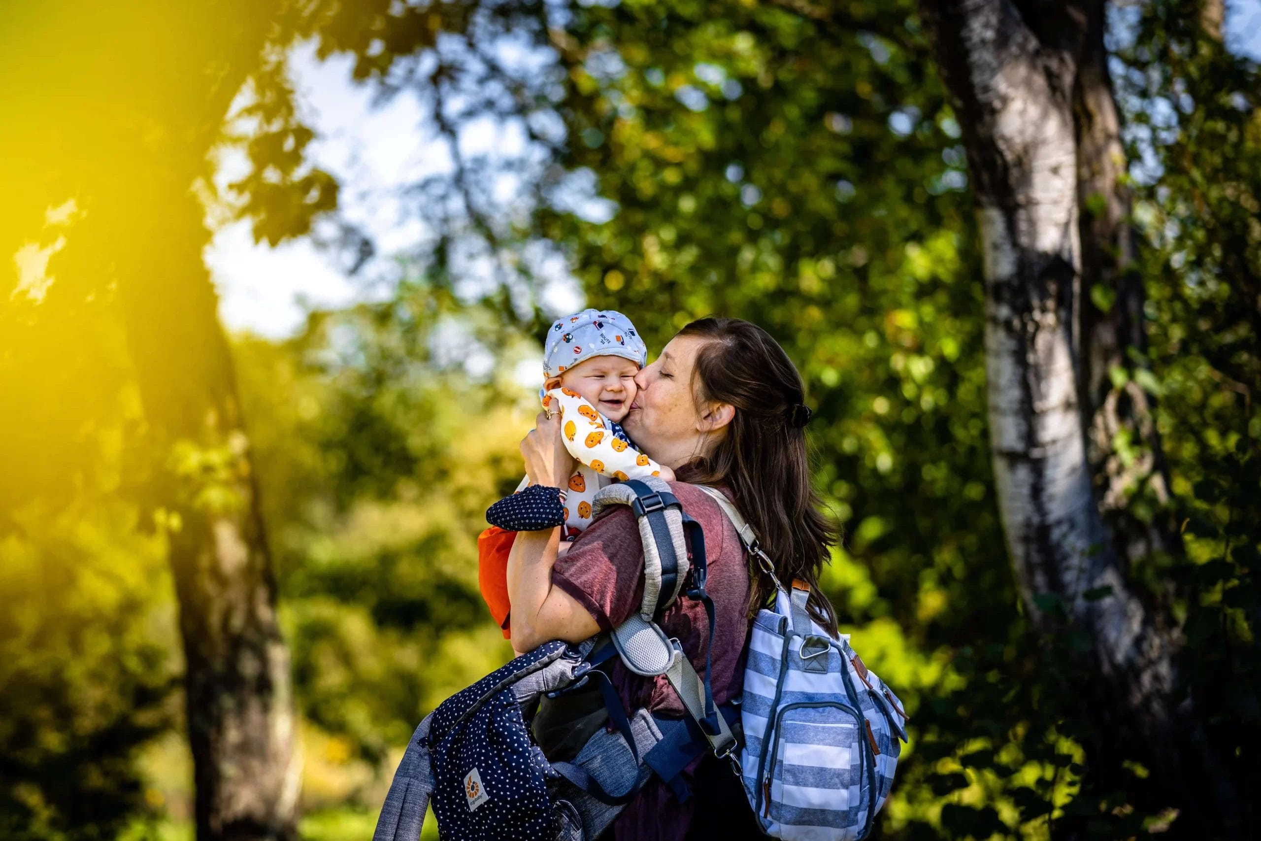 ibu menggendong tas bayi dan bayi