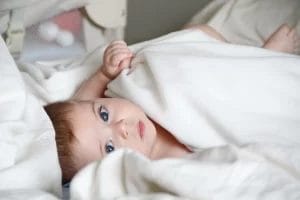 bayi bermata biru tidur di kasur bayi