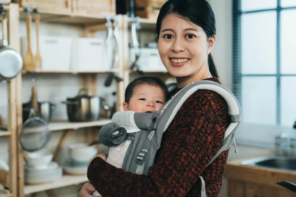 ibu menggendong bayi dengan gendongan bayi warna abu abu