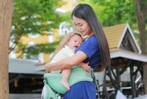 ibu menggendong bayinya dengan menggunakan hipseat