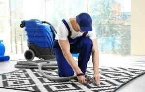 jasa cuci karpet sedang menyedot debu karpet