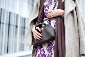 wanita berbaju ungu memakai shoulder bag warna cokelat tua