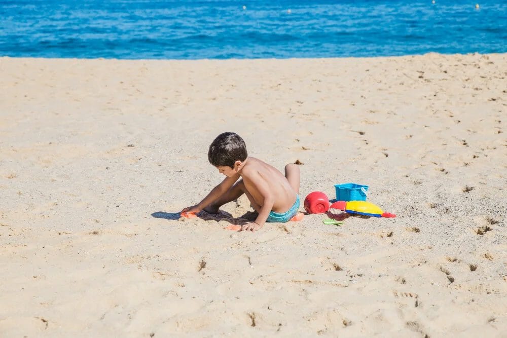 anak laki laki bermain di pantai