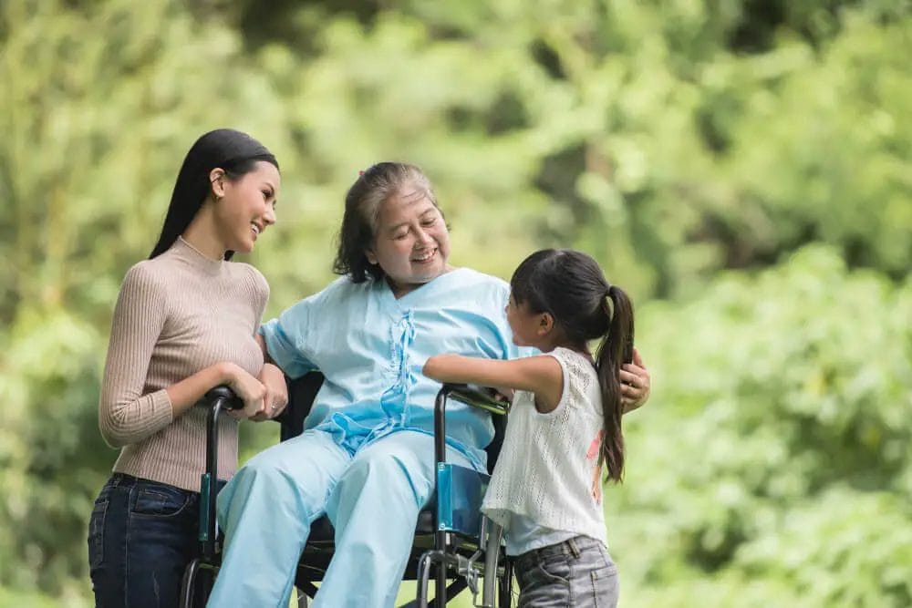 nenek duduk di kursi roda ditemani anaknya