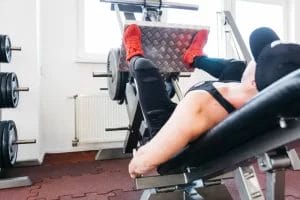 pria menggunakan leg press machine